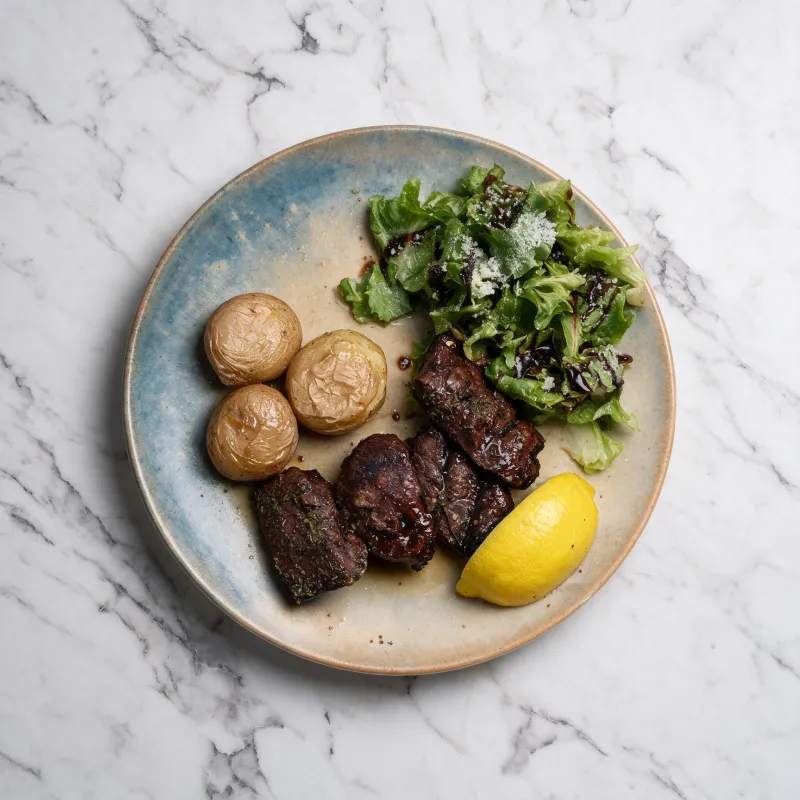 Grilled liver served with tender potatoes and a fresh salad