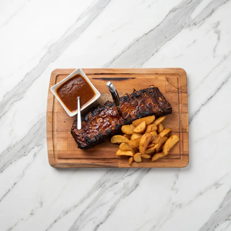 Glazed ribs with thick-cut fries and extra sauce on the side