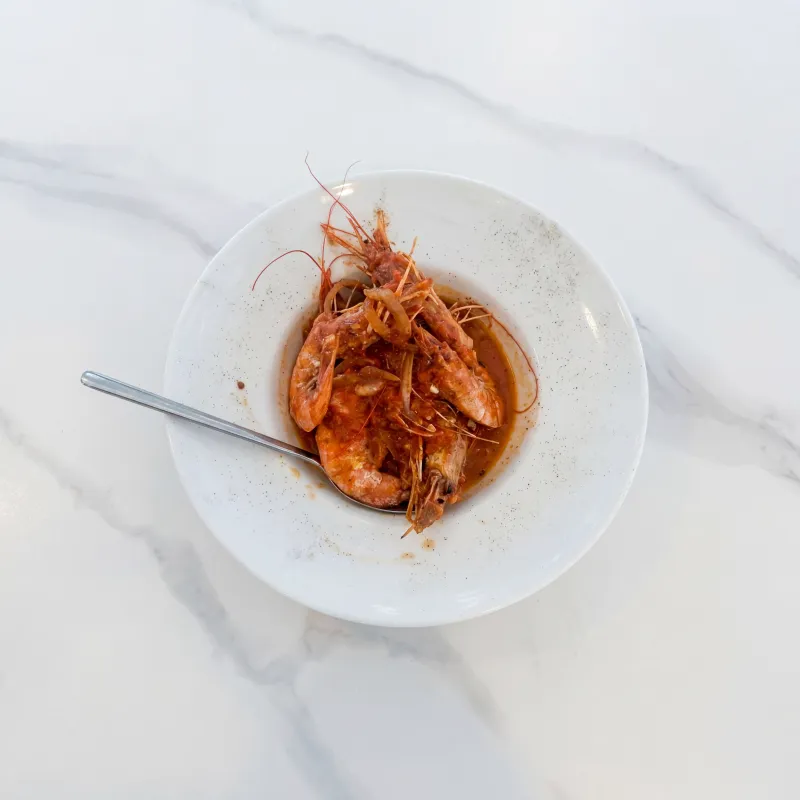 A bowl of red prawns in their own broth